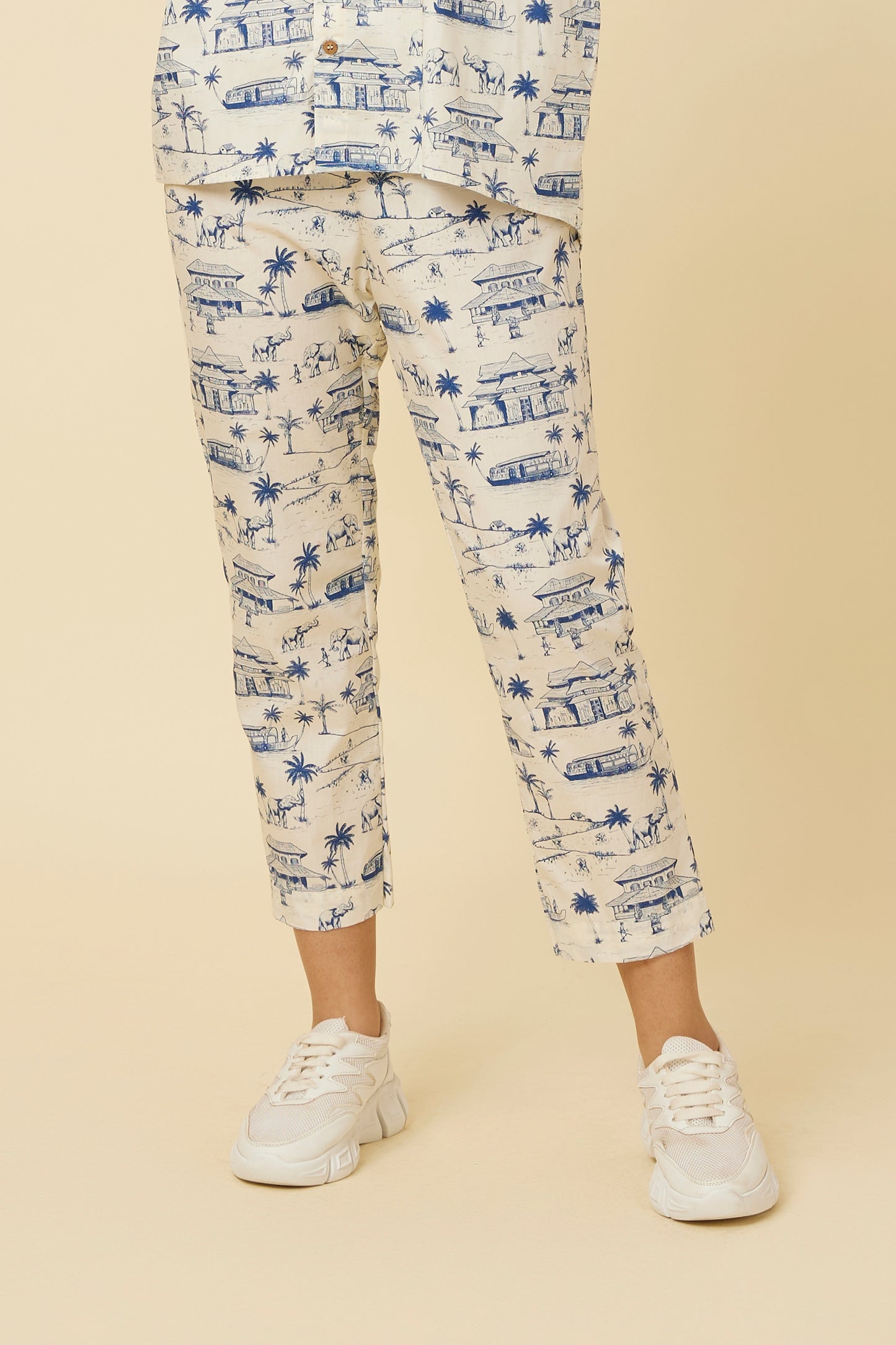 Close-up view of Homeland Pants featuring a classic straight hem, side pockets, and detailed Kerala print, paired with casual white sneakers