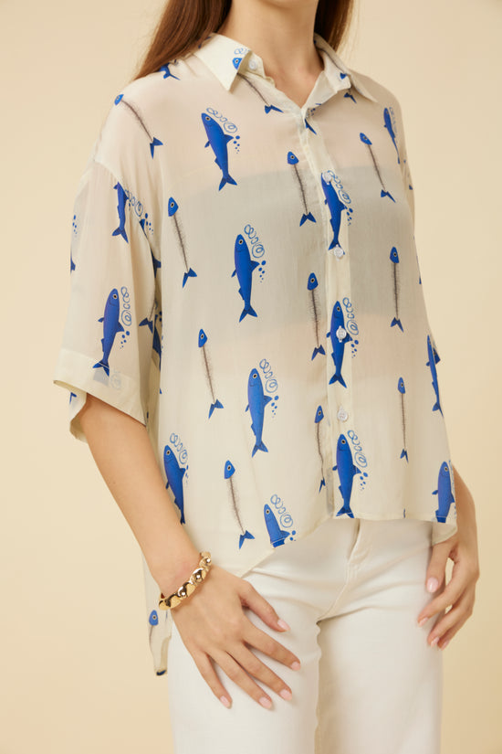Close-up of the Voyager Sheer Shirt in ivory with blue fish print, showcasing the elbow-length sleeves and sheer fabric design