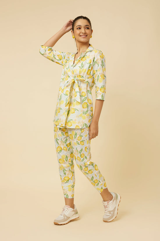 Model wearing the complete Citrus Dream set with full-sleeve shirt and fitted pants, illustrating the cohesiveness of the lemon tile print and the ensemble's modern flair with an innovative side-tie design.