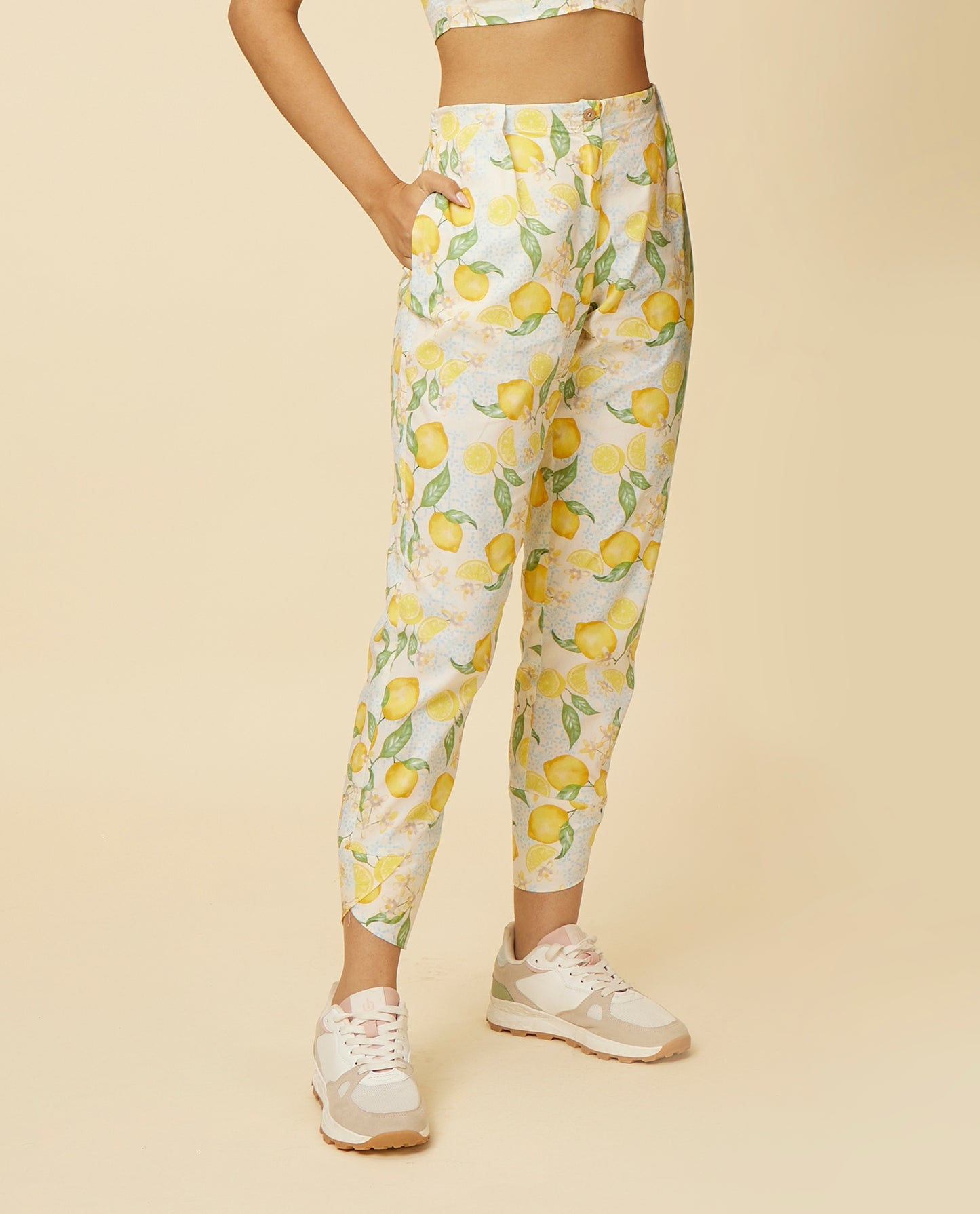 Detailed view of Citrus Dream Pants showcasing the zesty lemon tile print on a white base, focusing on the stylish tulip hem and the fit that offers a contemporary edge and a burst of freshness to the attire.