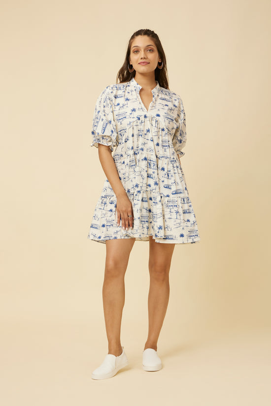 Model in a Homeland Print Dress with a yoke collar neckline and balloon sleeves, paired with white sneakers, embodying whimsical elegance
