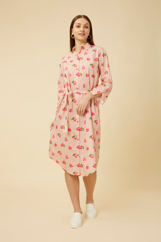 Model smiling in a Rose Apple Print shirt dress with a classic collar and waist tie for a cinched look, paired with white sneakers