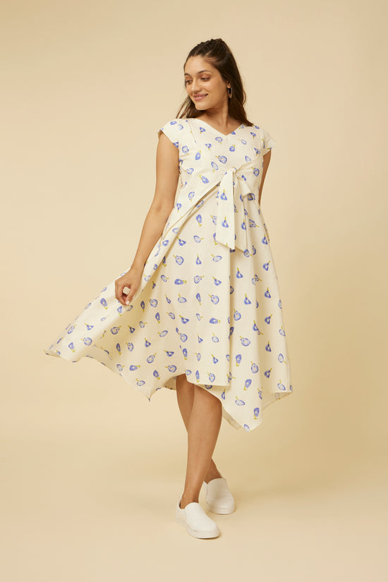 Joyful model twirling in Hypsway's Blue Pea Dress, highlighting the playful handkerchief hemline and the fluidity of the lightweight fabric adorned with blue pea florals, perfect for a breezy summer day.
